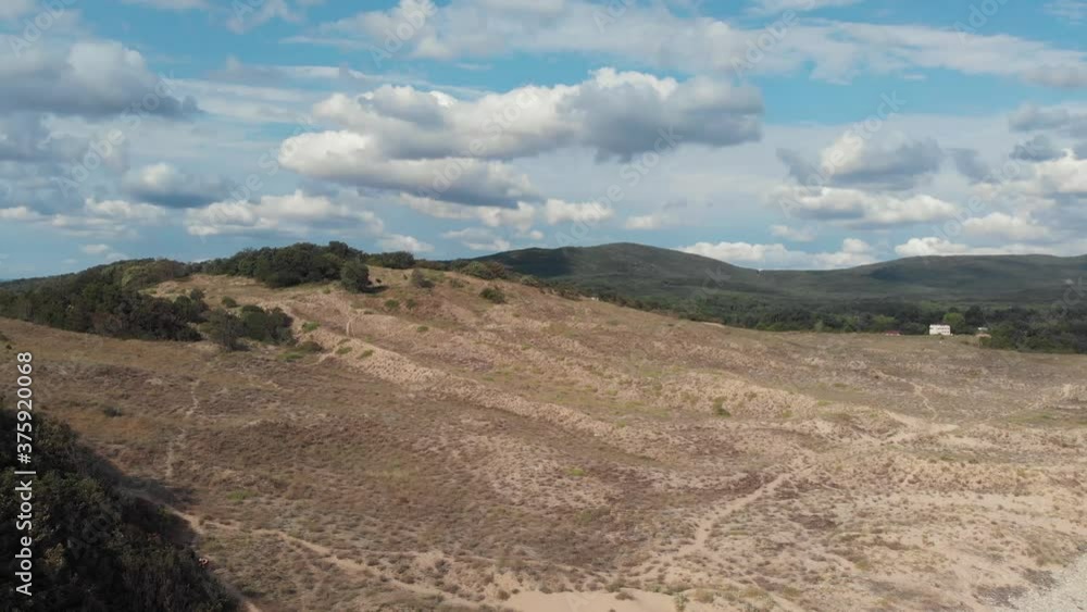 High sandy hill with green vegetation at the top. Shooting with a drone. High sandy hill with green vegetation at the top. Shooting with a drone.