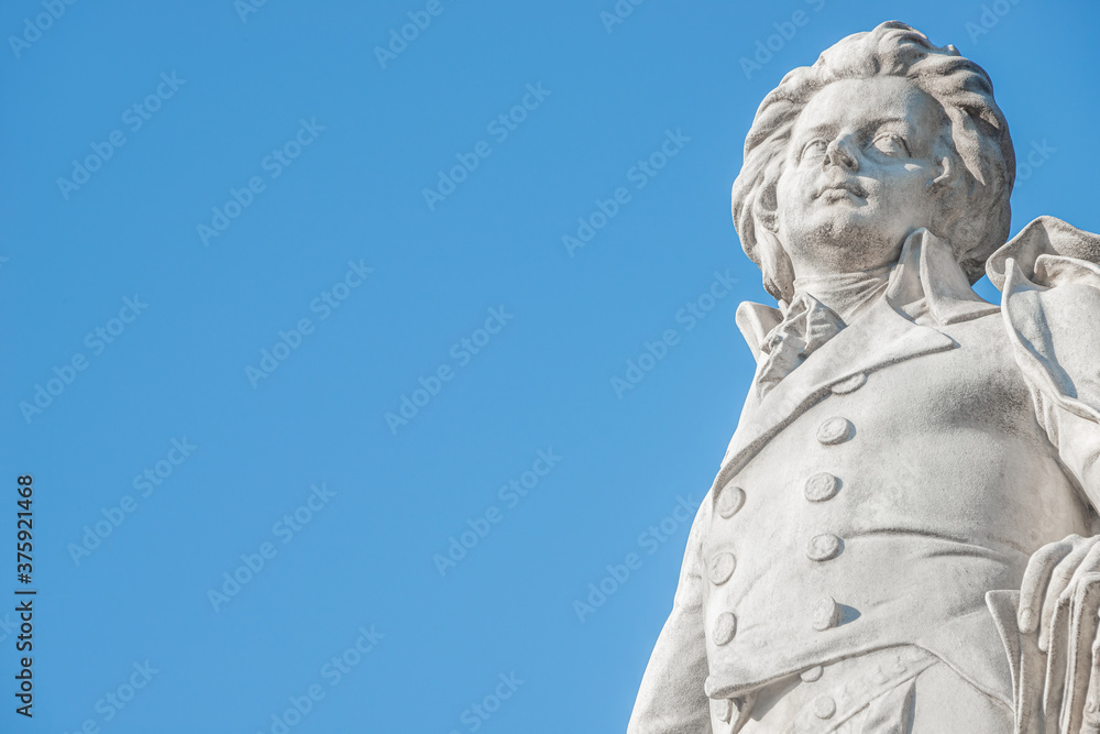Warm sunset over Mozart monument in front of Palmenhaus, near Neue Burg and Hofburg Palaces garden, in historical downtown of Vienna, Austria at sunny day, blue sky with copy space for text, details Warm sunset over Mozart monument in front of Palmenhaus, near Neue Burg and Hofburg Palaces garden, in historical downtown of Vienna, Austria at sunny day, blue sky with copy space for text, details