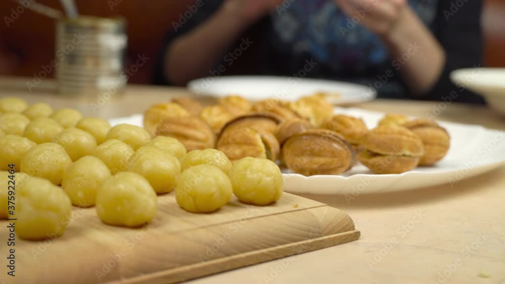 A woman makes dessert nuts with condensed milk, fills them in the kitchen with condensed milk. Homemade cake. A woman makes dessert nuts with condensed milk, fills them in the kitchen with condensed milk. Homemade cake.