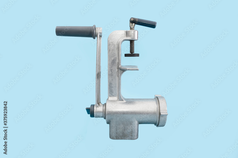 old manual meat grinder isolated on blue background.