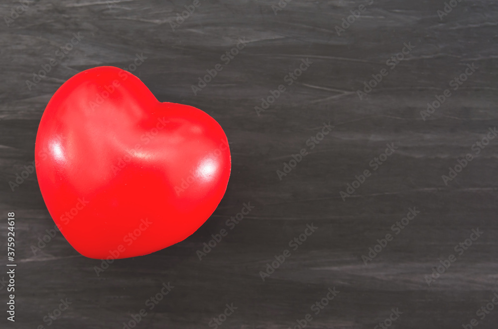 red heart on a black wooden background. Copy of space. Place for text and ideas. red heart on a black wooden background. Copy of space. Place for text and ideas.