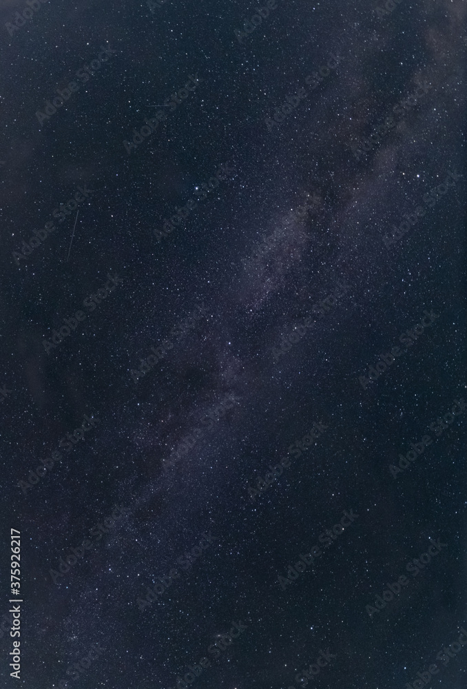 Panorama of the night sky. Milky Way. Falling stars. Background texture. Vertical photo