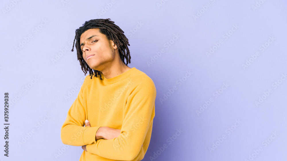 Young black man wearing rasta hairstyle suspicious, uncertain, examining you. Young black man wearing rasta hairstyle suspicious, uncertain, examining you.