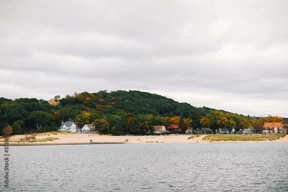 Fall landscape of the lake beach with walking people  in Michigan