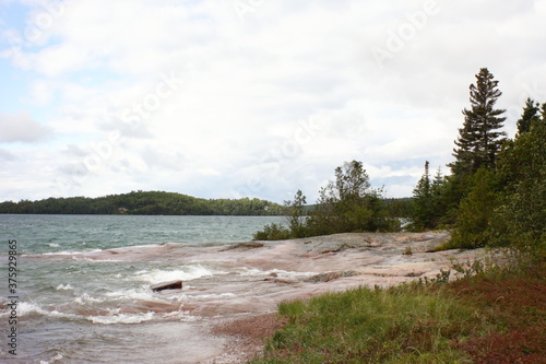 sandy beach in the afternoon light and wavy water