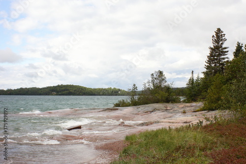 sandy beach in the afternoon light and wavy water