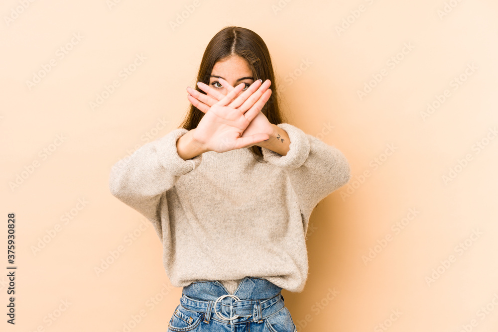 Young caucasian woman isolated en beige background doing a denial gesture Young caucasian woman isolated en beige background doing a denial gesture
