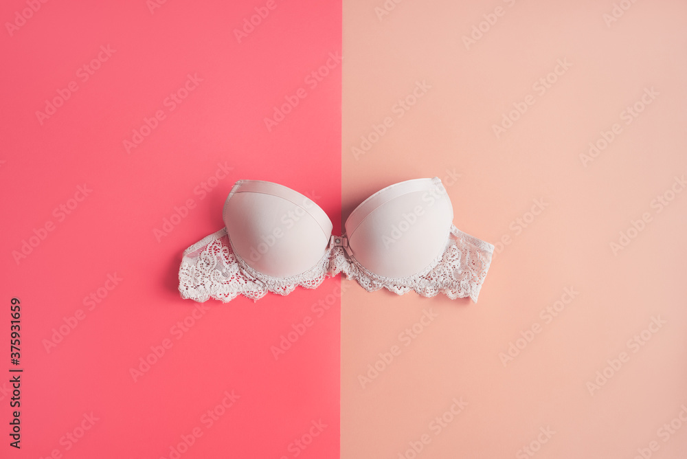 Classic bra of beige color on pink background. Women's lingerie