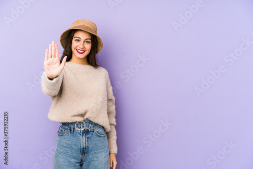 Young caucasian woman isolated on purple background smiling cheerful showing number five with fingers.