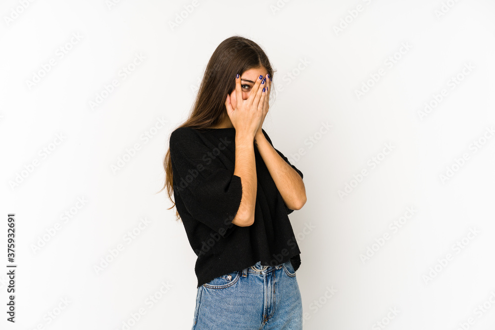 Young caucasian woman isolated on white background blink through fingers frightened and nervous. Young caucasian woman isolated on white background blink through fingers frightened and nervous.