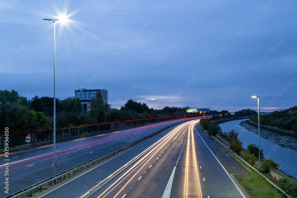 Light trails of cars speeding on a British Motorway before dawn