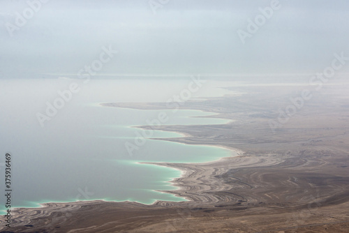 Fototapeta Naklejka Na Ścianę i Meble -  Twisting Dead Sea coastline in the fog.