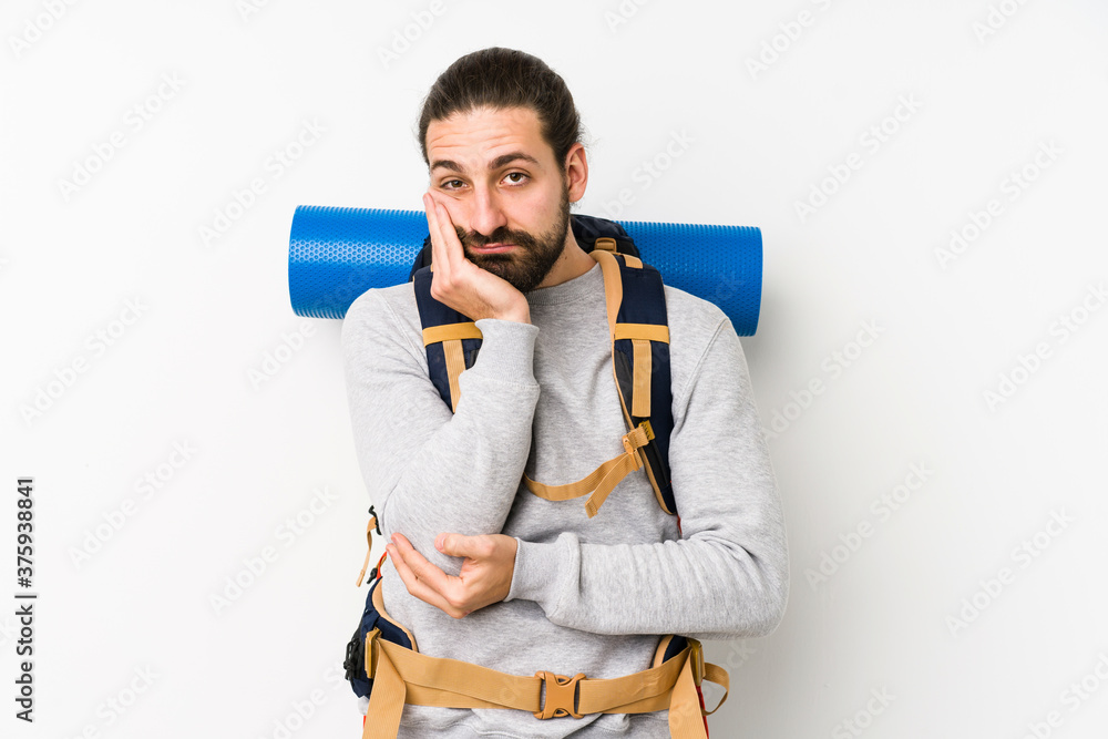 Young backpacker man isolated on a white background who is bored, fatigued and need a relax day. Young backpacker man isolated on a white background who is bored, fatigued and need a relax day.