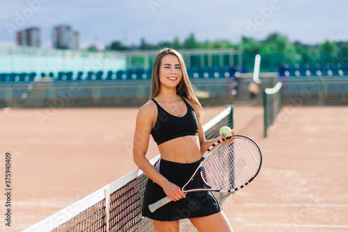 Beautiful stylish sexy woman in black trendy sportswear on tennis court. holding tennis racket © Ivan Zelenin