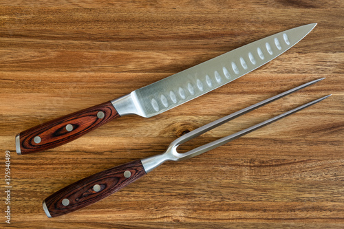 Photograph of knife and fork carving set on a wood cutting board