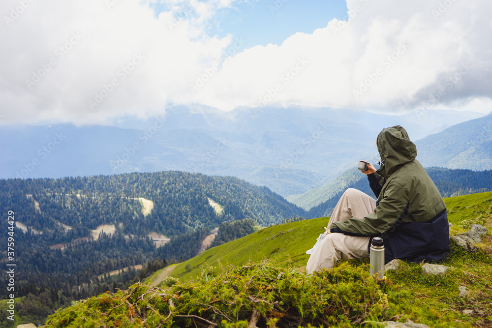 Naklejka premium Young woman hiker stand in beautiful mountains on hiking trip. Active tourist resting outdoors in nature. Backpacker camping outside recreation active