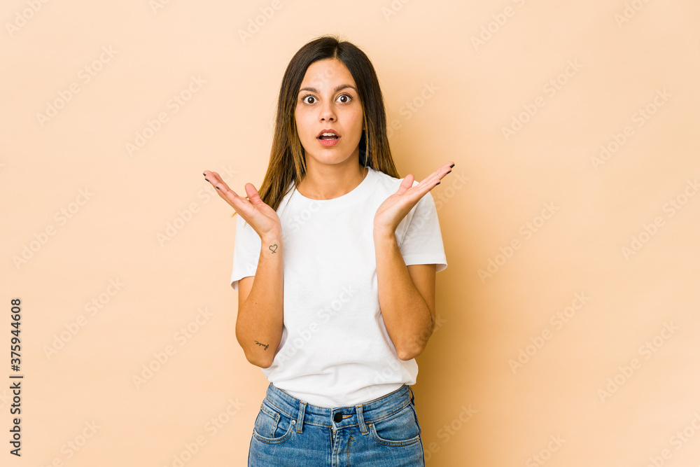 Young woman isolated on beige background surprised and shocked. Young woman isolated on beige background surprised and shocked.