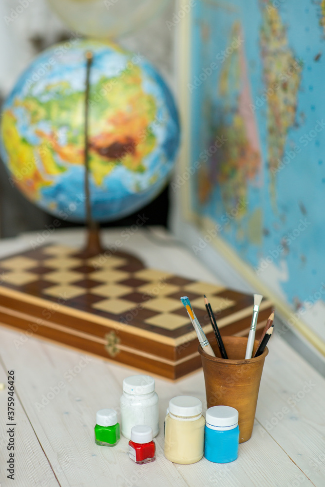 Brushes for drawing on a table with a globe. Schoolboy's Desk . Back to school. Brushes for drawing on a table with a globe. Schoolboy's Desk . Back to school.