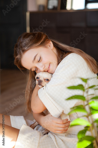 Schilderij op canvas Beautiful smiling girl hugs a chihuahua tightly