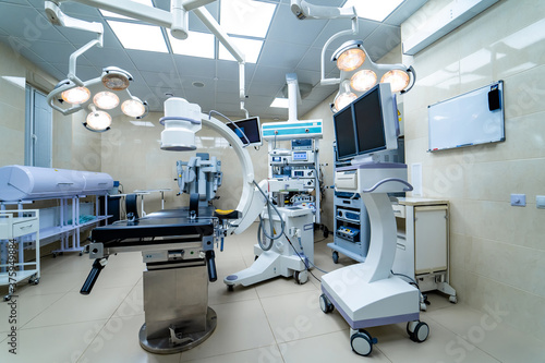 Modern well-equipped operating room. New medical equipment. Light white surgery room.