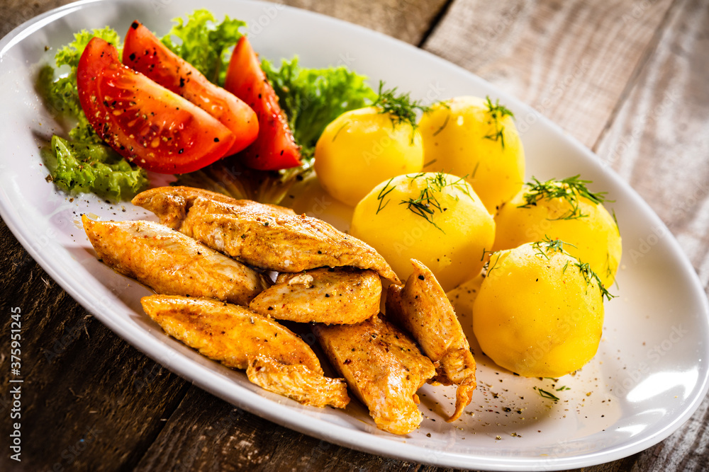 Chicken nuggets with boiled potatoes and vegetables on wooden table
Chicken nuggets with boiled potatoes and vegetables on wooden table