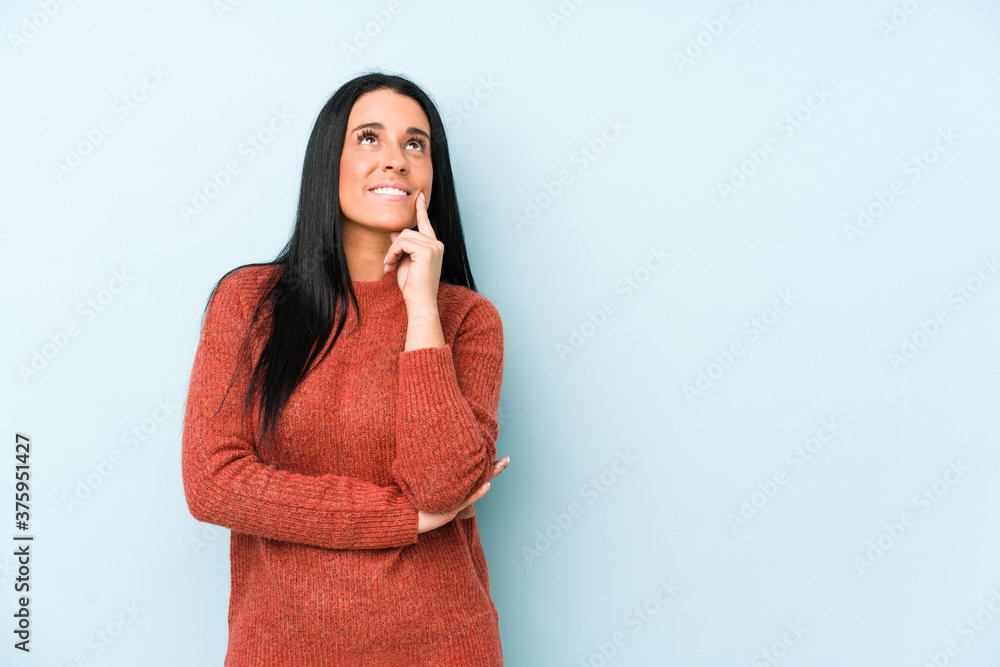Young caucasian woman isolated on a blue background looking sideways with doubtful and skeptical expression. Young caucasian woman isolated on a blue background looking sideways with doubtful and skeptical expression.