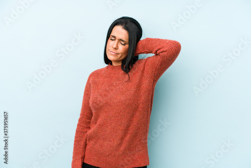Young caucasian woman isolated on a blue background suffering neck pain due to sedentary lifestyle. © Asier