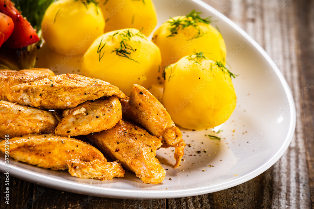Chicken nuggets with boiled potatoes and vegetables on wooden table
Chicken nuggets with boiled potatoes and vegetables on wooden table
