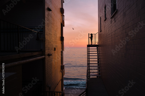 Silhouette of girl standing on staircase during sunset