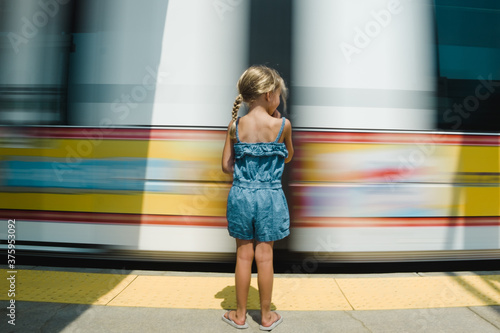 Rear view of girl waiting for train on platform