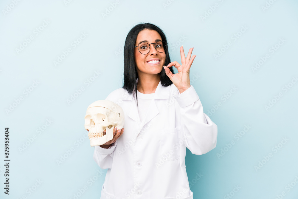 Doctor caucasian woman isolated on blue background cheerful and confident showing ok gesture.