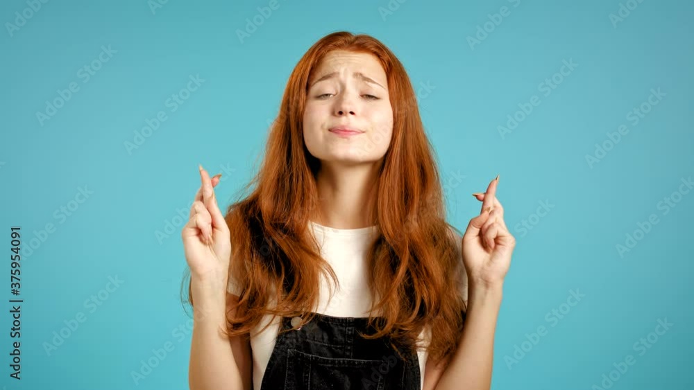 Cute young girl in dress praying over blue background. Woman begging someone satisfy her desires, help with. Cute young girl in dress praying over blue background. Woman begging someone satisfy her desires, help with.