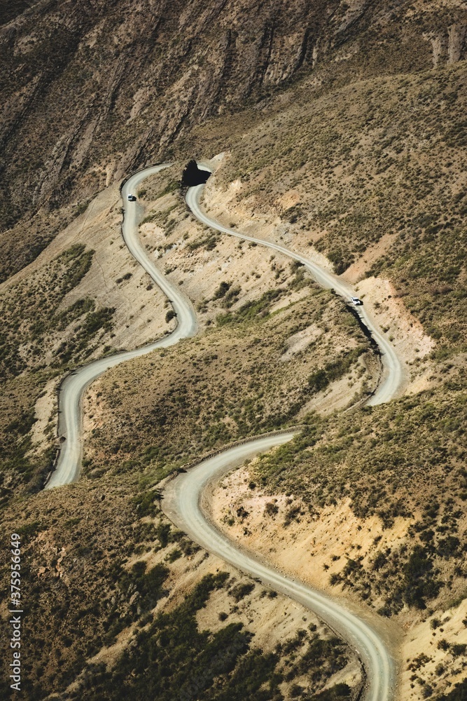 Narrow twisting dirt road across the Andes Mountains in Mendoza, Argentina.