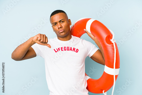 Young latin life guard isolated on blue background feels proud and self confident, example to follow. © Asier