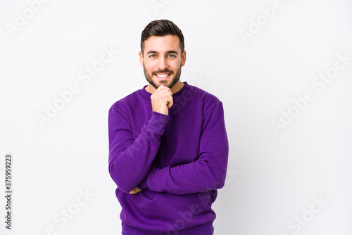 Young caucasian man against a white background isolated smiling happy and confident, touching chin with hand.