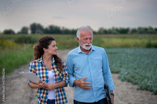 Fotografie Man and woman farmers walking in field