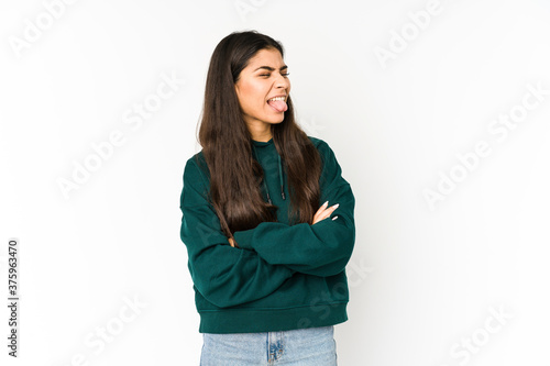 Young indian woman isolated on purple background funny and friendly sticking out tongue.