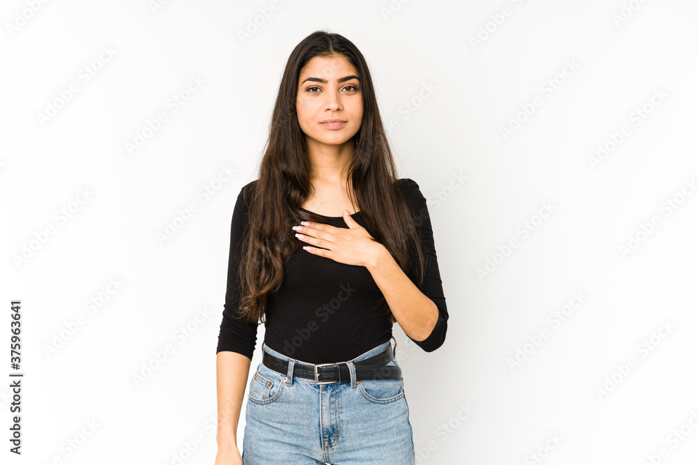 Young indian woman isolated on purple background taking an oath, putting hand on chest. Young indian woman isolated on purple background taking an oath, putting hand on chest.
