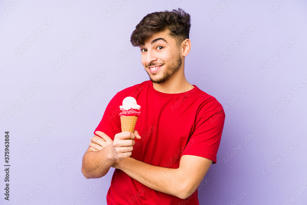 Young arabian man holding a ice cream laughing and having fun. Young arabian man holding a ice cream laughing and having fun.