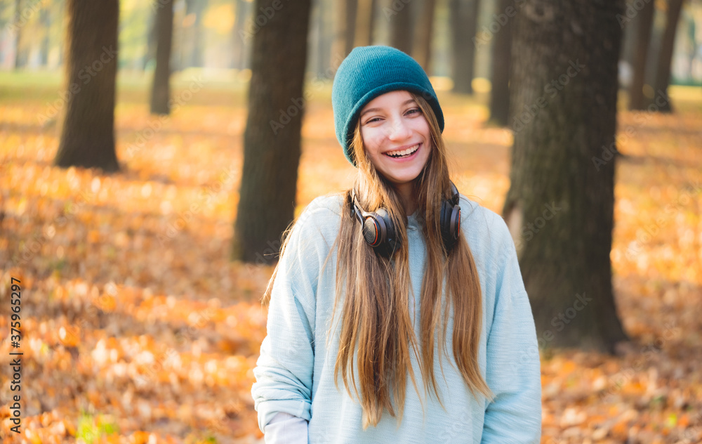 Nice girl with headphones in autumnal nature Nice girl with headphones in autumnal nature