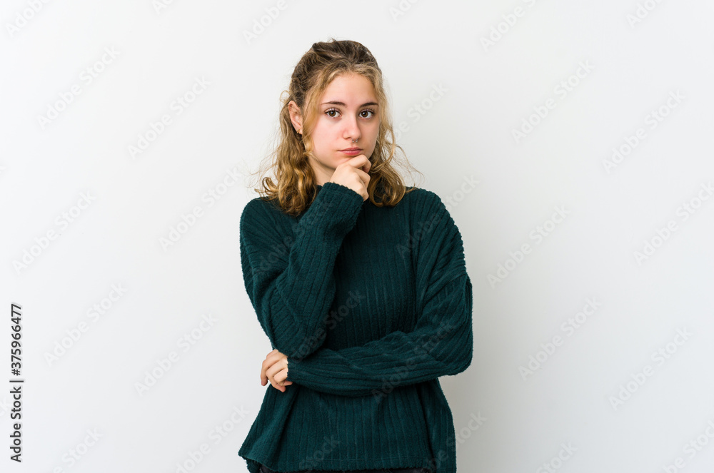 Young caucasian woman on white backrgound suspicious, uncertain, examining you. Young caucasian woman on white backrgound suspicious, uncertain, examining you.