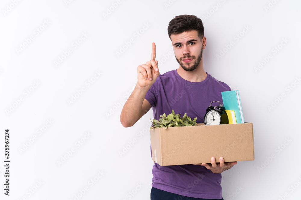 Young caucasian man moving a new home isolated showing number one with finger. Young caucasian man moving a new home isolated showing number one with finger.