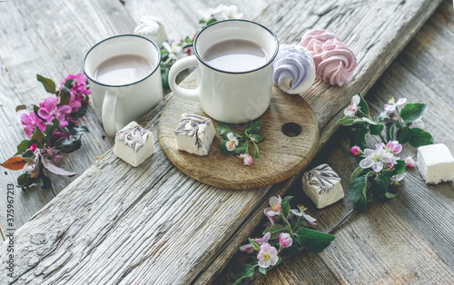 Cups with cocoa and marshmallows and flowers