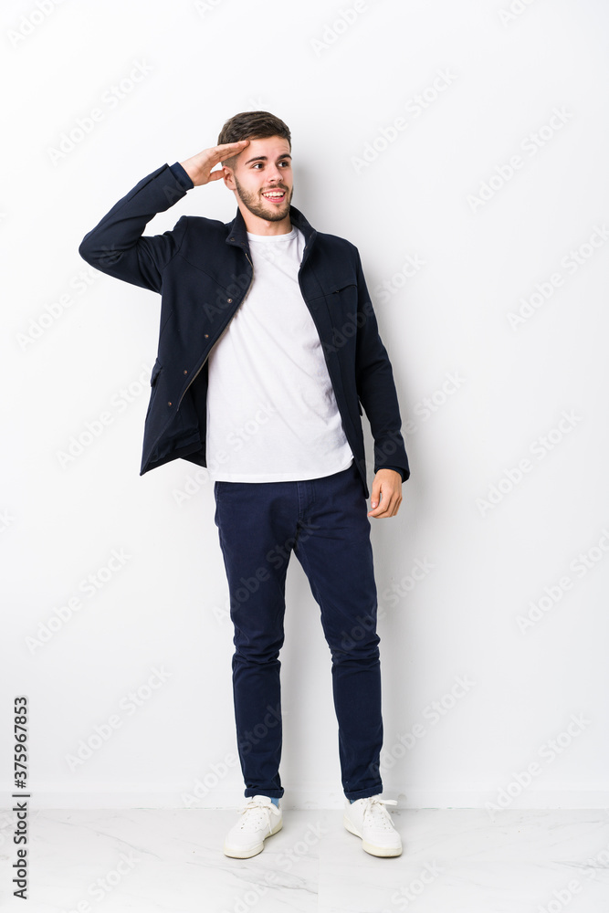 Full body young caucasian man isolated looking far away keeping hand on forehead. Full body young caucasian man isolated looking far away keeping hand on forehead.