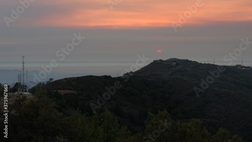 Sunset views in Santa Cruz mountains; Red setting sun barely visible through the smoke cloud from the nearby burning wildfires; South San Francisco Bay Area, California