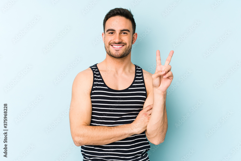Young caucasian man isolated on blue background showing number two with fingers. Young caucasian man isolated on blue background showing number two with fingers.