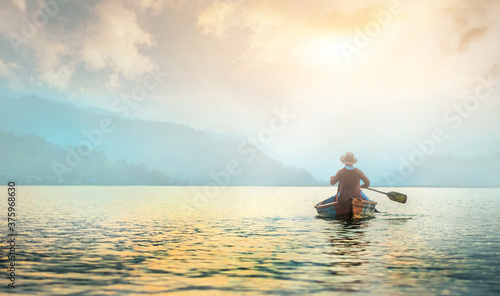 Back view of lonely fisherman in boat on morning lake © Ievgen Skrypko