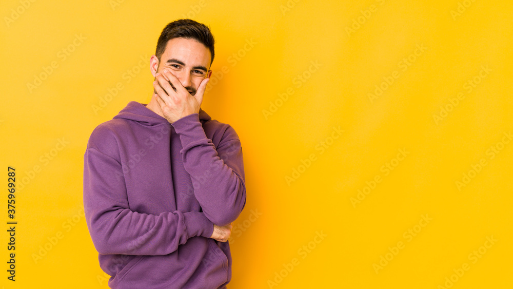 Young caucasian man isolated on yellow bakground laughing happy, carefree, natural emotion. Young caucasian man isolated on yellow bakground laughing happy, carefree, natural emotion.