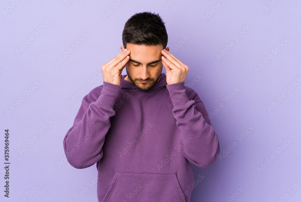 Young caucasian man isolated on purple background touching temples and having headache. Young caucasian man isolated on purple background touching temples and having headache.