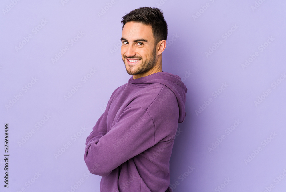 Obraz premium Young caucasian man isolated on purple background happy, smiling and cheerful.